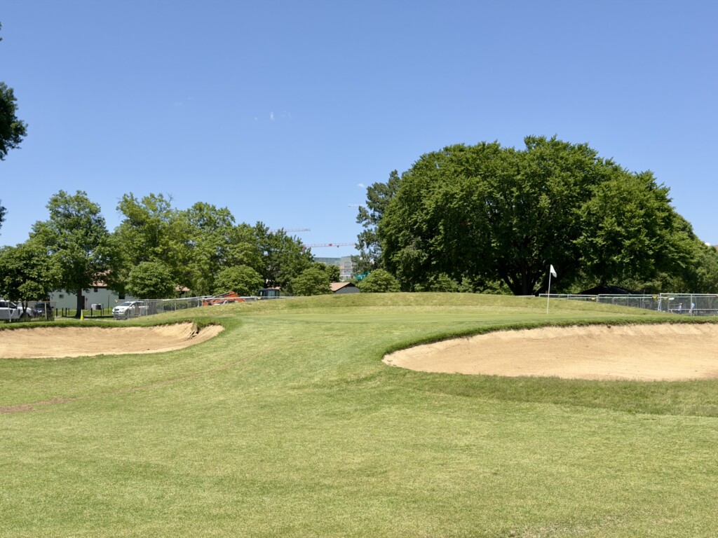 Fifth green at East Potomac White Course, bunkers guarding the front-left and front-right, white flag on the right side
