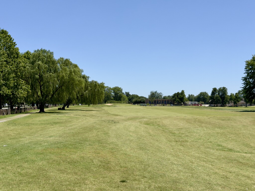 Seventh fairway at East Potomac White Course from the tee, willow line down the left, greenside bunker and mounding in the distance