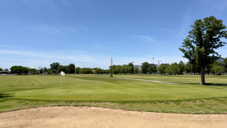 East Potomac Golf Links White Course ninth green with greenside bunker, Washington Monument visible down the eighth fairway.