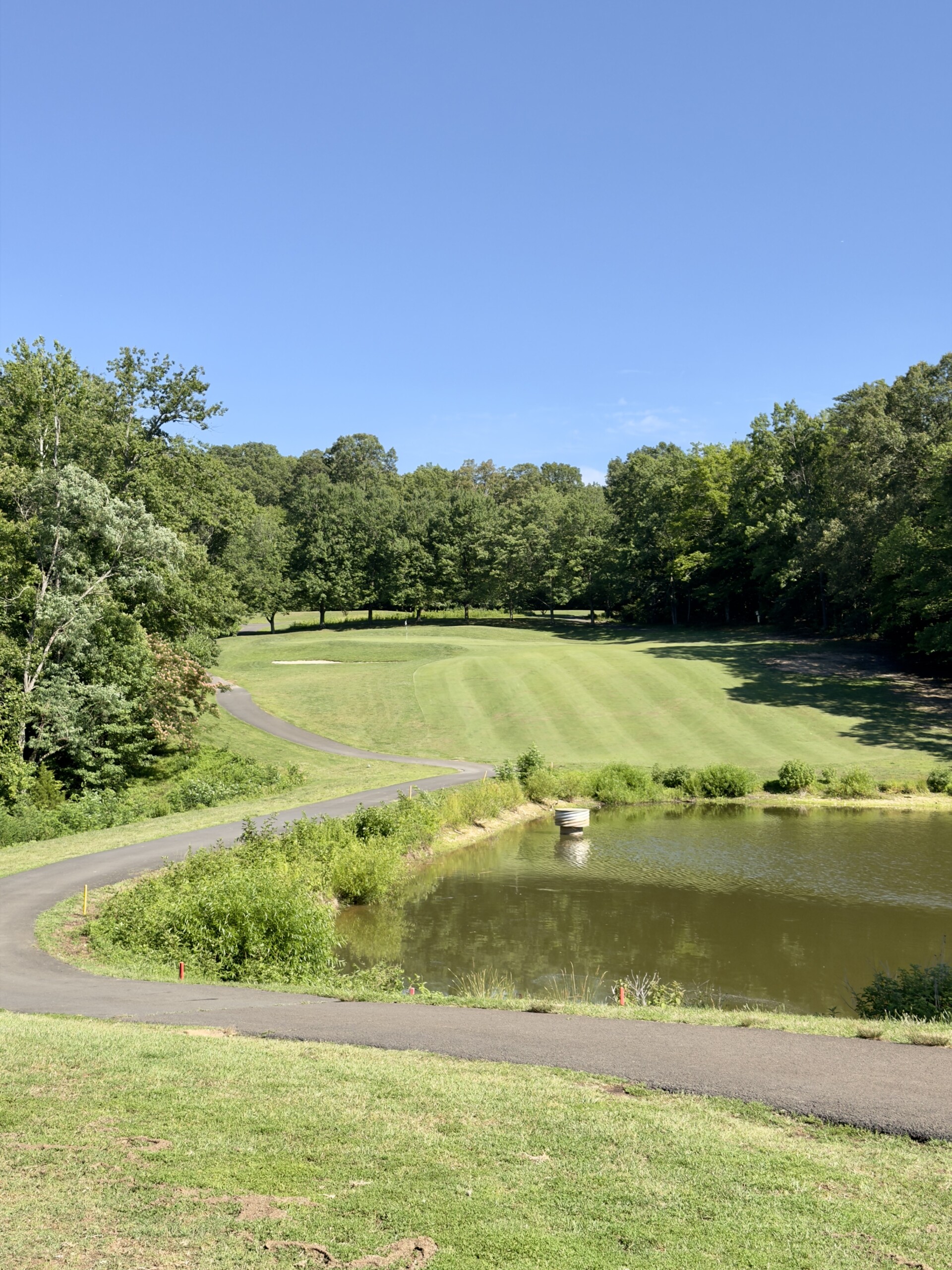 Approach to the par-5 13th green at Pohick Bay Golf Course, a pond guarding short-right and a bunker front-left