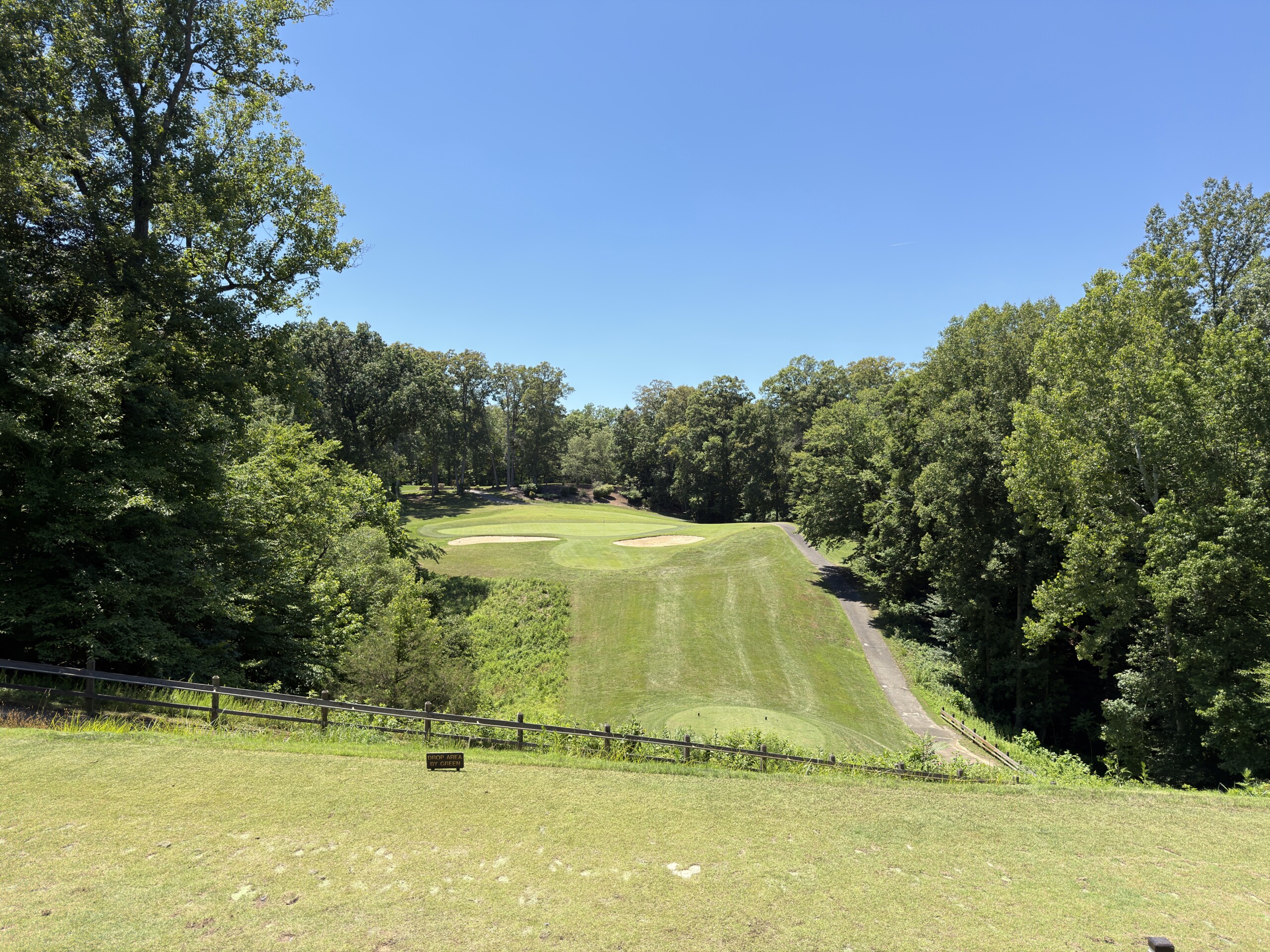 Elevated tee on the par-3 2nd at Pohick Bay Golf Course, the green set across a deep wooded ravine between two bunkers